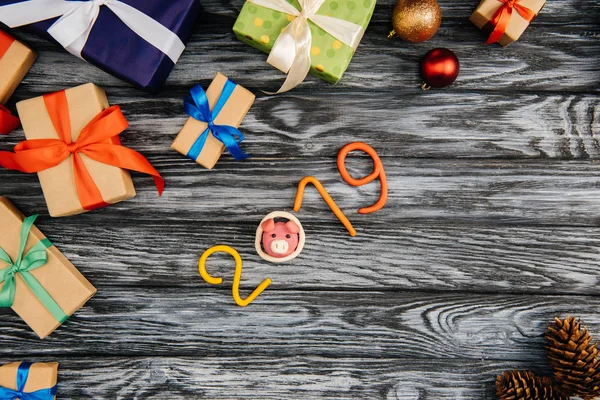 Vue du dessus du symbole 2019 et des cadeaux de Noël sur une surface en bois — Photo de stock