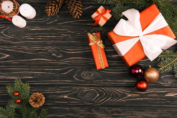 Vista superior de cajas de regalo, bolas de Navidad y ramas de abeto en la superficie de madera - foto de stock