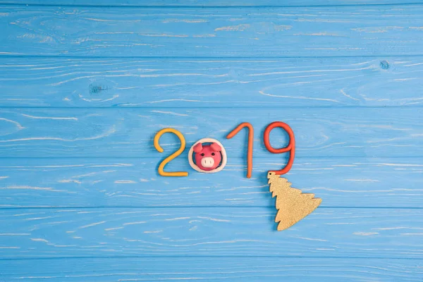 Ansicht von 2019 mit Symbol, Schwein und Christbaum auf blauer Holzoberfläche — Stockfoto