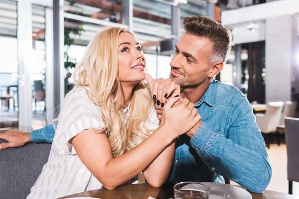 Щаслива пара тримає руки під час побачення в кафе — стокове фото