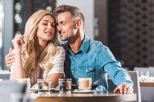 Couple affectueux câlins à la table dans le café pendant la date — Photo de stock
