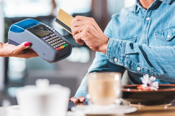 Abgeschnittenes Bild von Mann, der im Café mit Kreditkarte bezahlt — Stockfoto