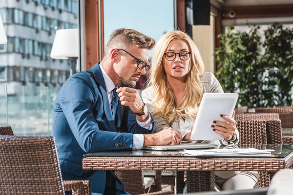 Businesspeople using tablet while discussing work during meeting in cafe — Stock Photo