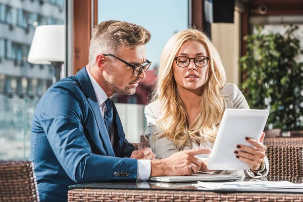 Businesspeople using tablet while discussing work during meeting in cafe — Stock Photo