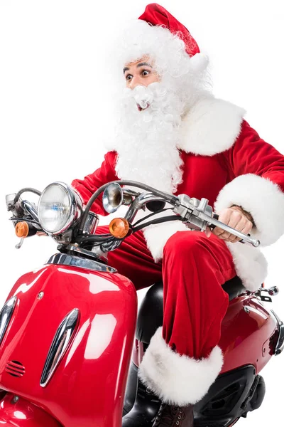 Surprised santa claus in costume riding on scooter isolated on white background — Stock Photo