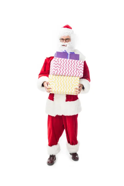 Santa claus in eyeglasses holding pile of christmas presents isolated on white background — Stock Photo