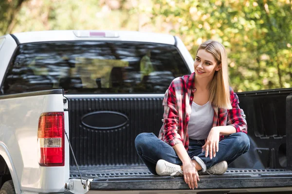 Foco seletivo da jovem mulher sentada no porta-malas do carro pick up ao ar livre — Fotografia de Stock