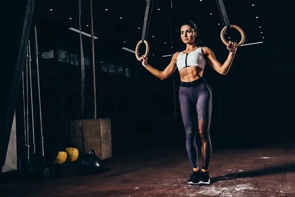 Приваблива спортивна жінка, що працює з гімнастичними кільцями — стокове фото