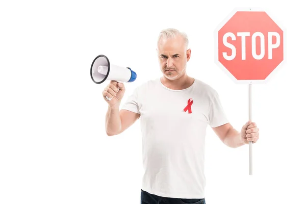 Homme mature en colère en blanc blanc t-shirt avec des aides conscience ruban rouge, stop panneau routier et mégaphone isolé sur blanc — Photo de stock