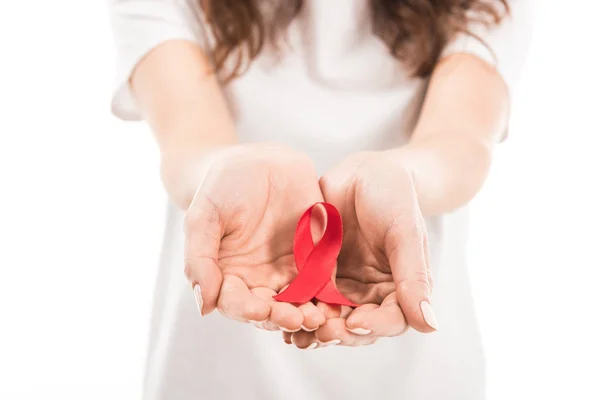 Tiro recortado de la mujer que sostiene ayudas conocimiento cinta roja aislada en blanco - foto de stock