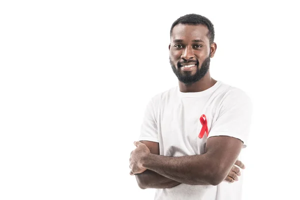 Handsome african american man in blank white t-shirt with aids awareness red ribbon looking at camera isolated on white — Stock Photo