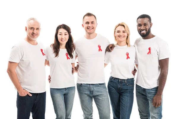 Fröhliche Gruppe von Menschen in weißen T-Shirts mit Hilfsmitteln und roten Bändern, die isoliert auf weiß in die Kamera schauen — Stockfoto