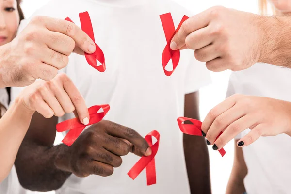 Cropped shot of group of people in blank white t-shirts holding aids awareness red ribbons — Stock Photo