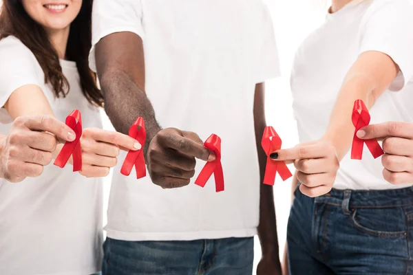 Cropped shot of group of people in blank white t-shirts holding aids awareness red ribbons isolated on white — Stock Photo