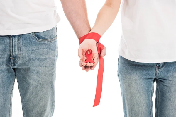 Recortado disparo de pareja cogido de la mano atado con cinta roja aislado en blanco, SIDA concepto de día de conciencia - foto de stock