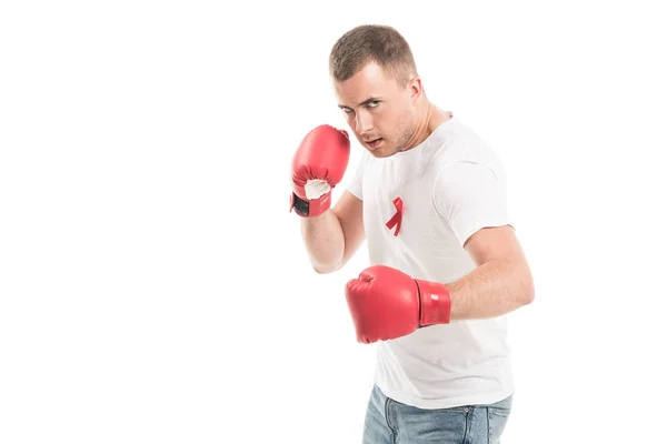 Forte bell'uomo in bianco bianco t-shirt con aiuti consapevolezza nastro rosso e guanti da boxe isolati su bianco, concetto di aiuti lotta — Foto stock