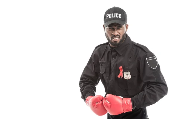 Arrabbiato agente di polizia afroamericano con i guanti da boxe isolati su bianco, concetto di lotta contro gli aiuti — Foto stock