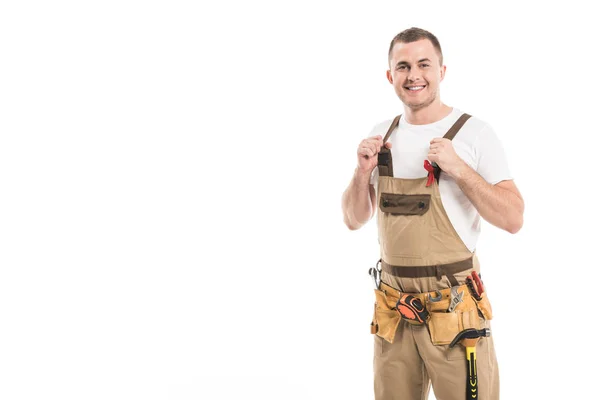 Handsome adult builder with aids awareness red ribbon on overall looking at camera isolated on white — Stock Photo