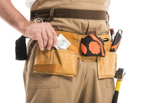 Cropped shot of builder taking condom from pocket isolated on white — Stock Photo