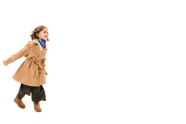 Linda criança em casaco de trincheira correndo isolado em branco — Fotografia de Stock