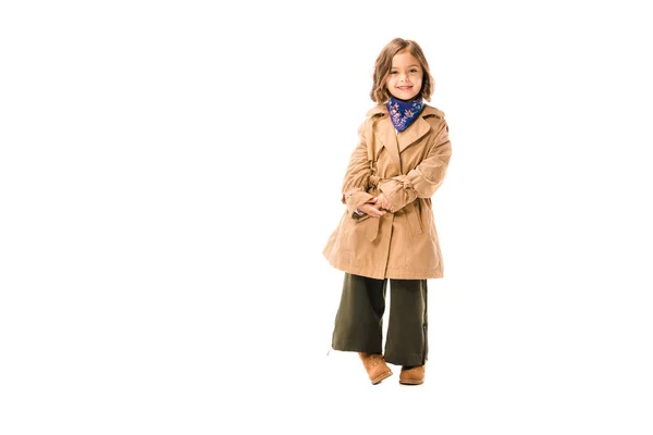 Linda criança em casaco de trincheira olhando para a câmera isolada no branco — Fotografia de Stock