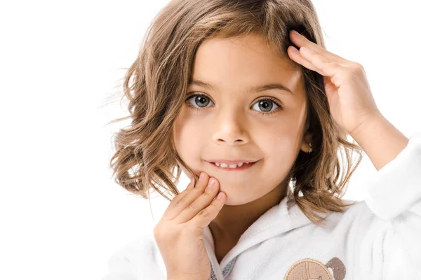 Portrait d'adorable enfant en peignoir blanc touchant visage isolé sur blanc — Photo de stock