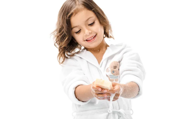 Retrato de niño sonriente en albornoz lavándose las manos con jabón aislado en blanco - foto de stock