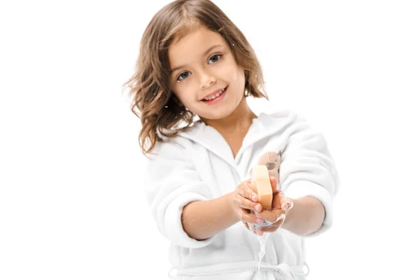 Portrait of smiling kid in bathrobe washing hands with soap isolated on white — Stock Photo