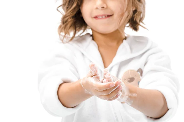 Vue partielle de l'enfant en peignoir se laver les mains avec du savon isolé sur blanc — Photo de stock