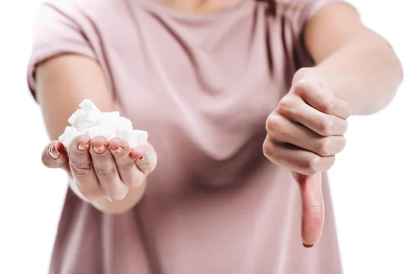 Corte close up de mulher segurando açúcar branco não saudável e mostrando polegar para baixo isolado no branco — Fotografia de Stock
