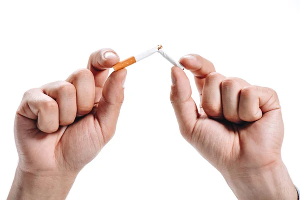 Обрізане зображення чоловіка, що ламає нездорову сигарету ізольовано на білому — стокове фото