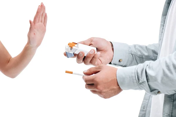 Immagine ritagliata donna respingere pacchetto di sigarette da uomo isolato su bianco — Foto stock
