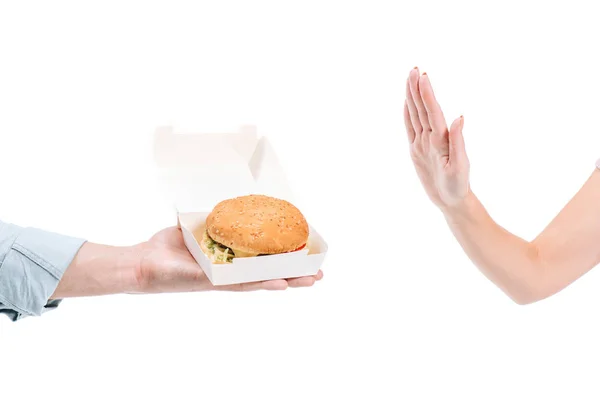 Abgeschnittenes Bild von Frau, die ungesunden Burger auf Weiß ablehnt — Stockfoto