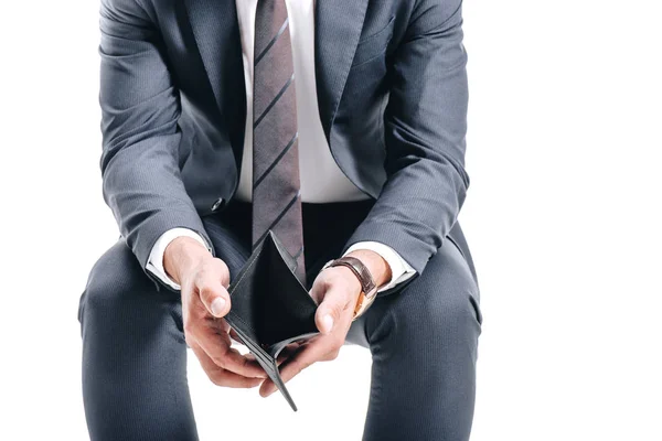 Abgeschnittenes Bild eines Geschäftsmannes, der mit offenem leeren Portemonnaie auf weißem Hintergrund sitzt — Stock Photo