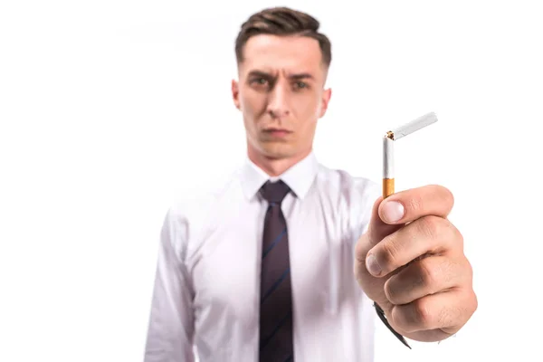 Enfoque selectivo de hombre de negocios sosteniendo cigarrillo roto malsano aislado en blanco - foto de stock