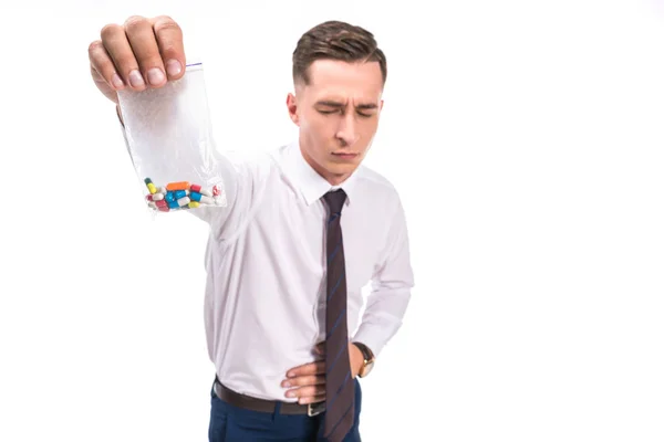 Enfoque selectivo de hombre de negocios que muestra dolor de estómago y la celebración de píldoras de drogas de color aislado en blanco - foto de stock