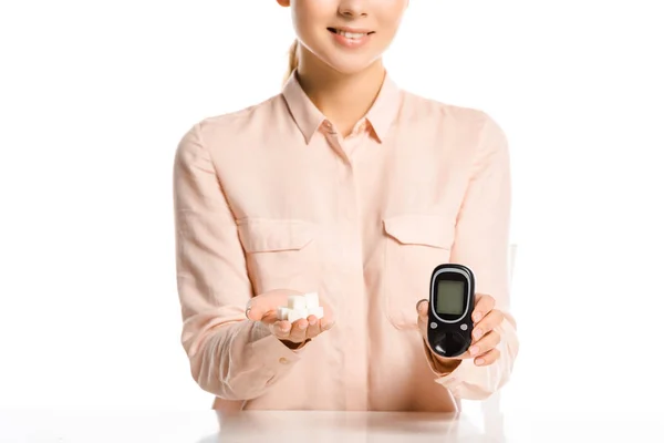 Abgeschnittenes Bild einer lächelnden Frau mit raffiniertem Zucker und Glukometer isoliert auf weißem, Diabetes-Konzept — Stockfoto