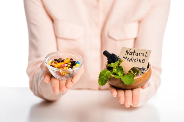 Image recadrée de femme tenant des bols avec de l'huile de médecine naturelle et des médicaments pharmacologiques isolés sur blanc — Photo de stock