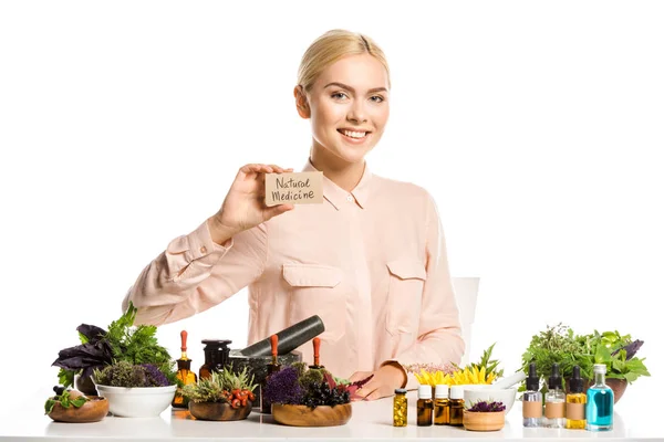 Sonriente mujer sosteniendo tarjeta con signo de medicina natural aislado en blanco - foto de stock