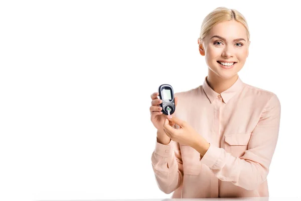 Mulher sorrindo colocando tira em glicosímetro isolado em branco, conceito de diabetes — Fotografia de Stock