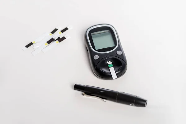 Medizinisches Glukometer und Streifen isoliert auf weiß — Stockfoto