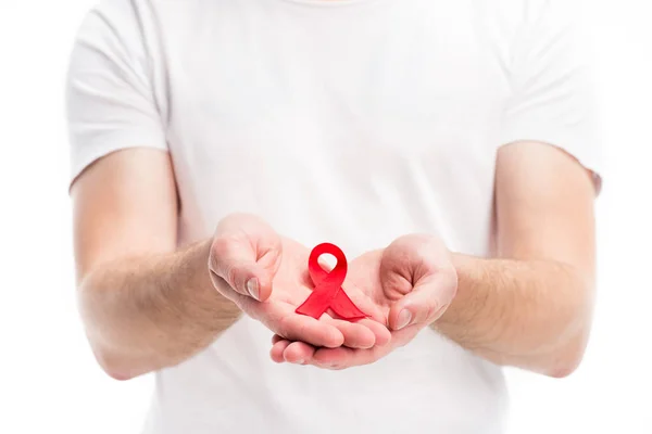 Imagen recortada del hombre mostrando cinta roja en las manos aisladas en blanco, concepto del día del sida mundial — Stock Photo