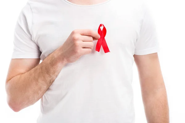 Sección media del hombre que pone la cinta roja en la camisa aislada en blanco, concepto del día del sida del mundo — Stock Photo