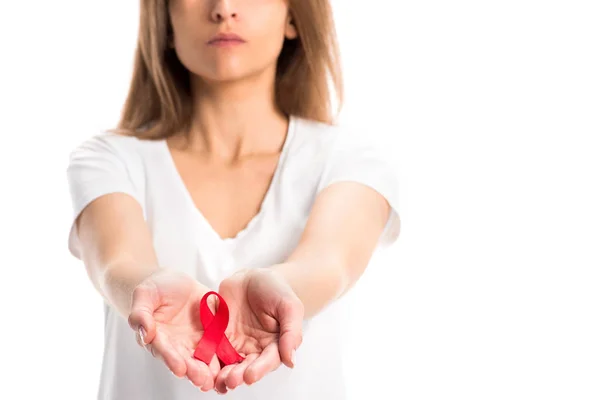 Image recadrée de la femme tenant un ruban rouge dans les mains isolées sur blanc, concept de journée mondiale des aides — Photo de stock