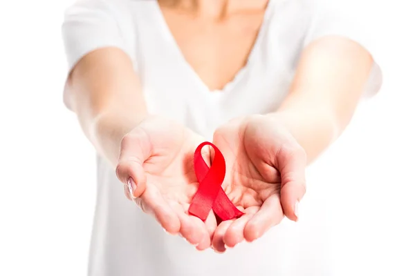 Imagen recortada de la mujer que muestra la cinta roja en las manos aisladas en blanco, concepto del día del sida mundial — Stock Photo