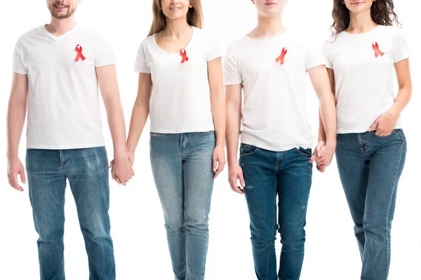 Imagen recortada de los hombres en las mujeres con cintas rojas tomados de las manos aislados en blanco, el mundo SIDA concepto del día - foto de stock