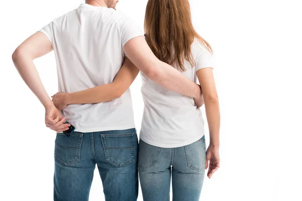 Vista posteriore di coppia eterosessuale abbracciare isolato su bianco, fidanzato prendendo preservativo, world aids day concept — Foto stock