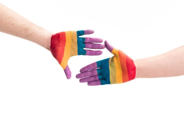 Image recadrée de couple gay toucher avec les mains peintes dans les couleurs de la fierté drapeau isolé sur blanc, monde sida concept de jour — Photo de stock