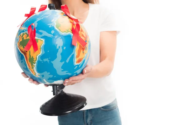 Abgeschnittenes Bild einer Frau im weißen Hemd mit Globus und roten Bändern auf weißem Hintergrund, Konzept zum Welthilfetag — Stockfoto