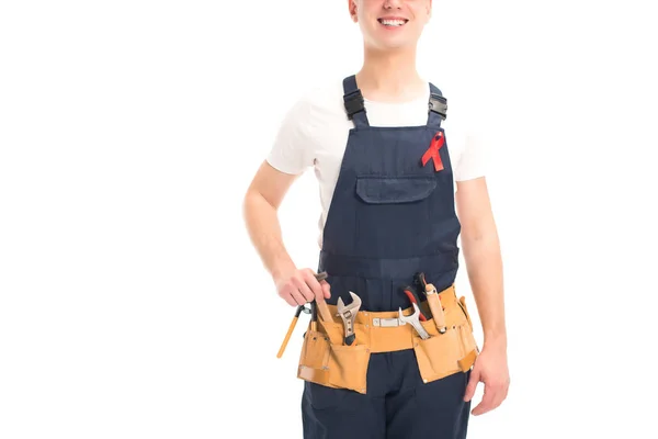 Imagen recortada de trabajador sonriente en uniforme y cinta roja parado aislado en blanco, concepto del día del sida del mundo - foto de stock